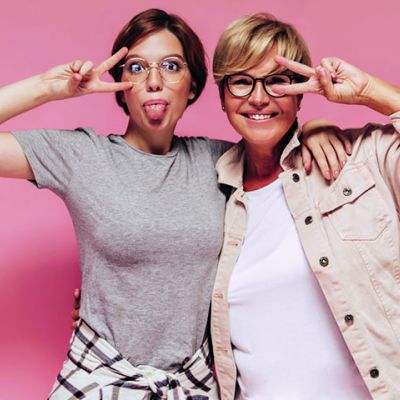 COVER-Modnefrizure-pomladijo_0000_funny-girl-with-glasses-plaid-shirt-showing-tongue-peace-sign-together-with-blonde-lad